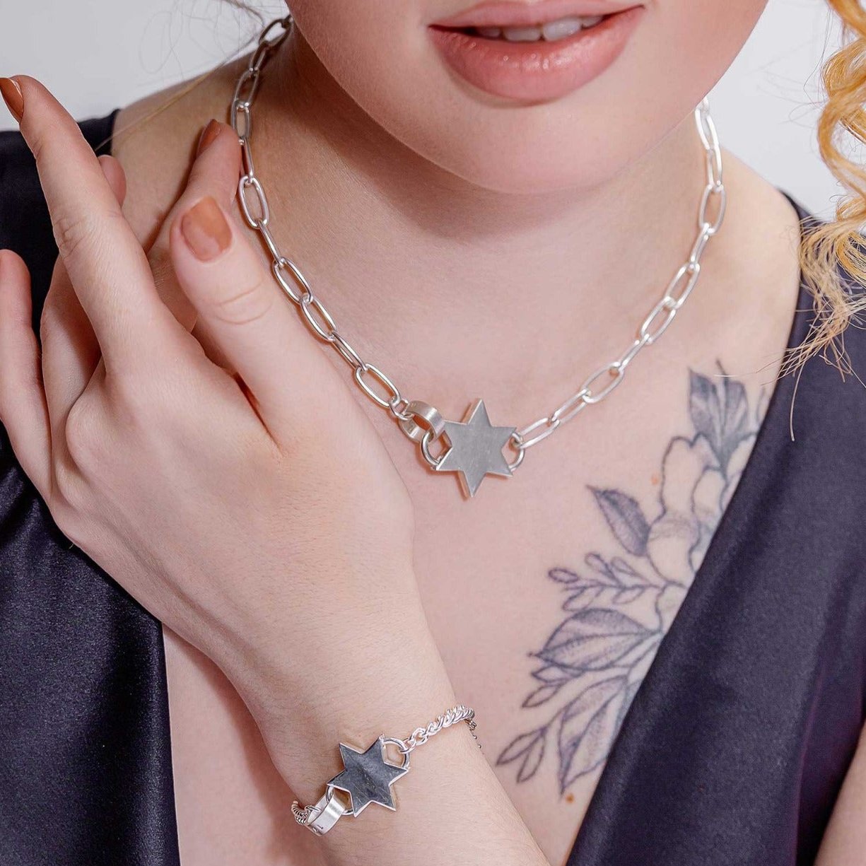 Model wearing a layered silver star pendant necklace paired with matching silver star bracelet, showcasing a unique and versatile look.