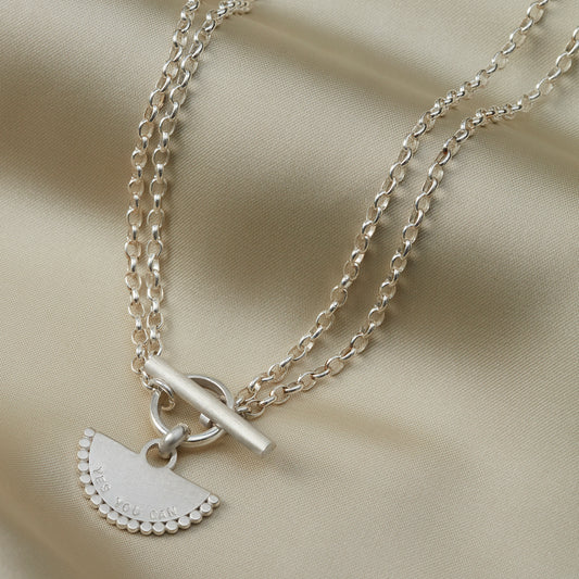 Close-up of the personalised fan pendant necklace in sterling silver with dotted edge detailing.
