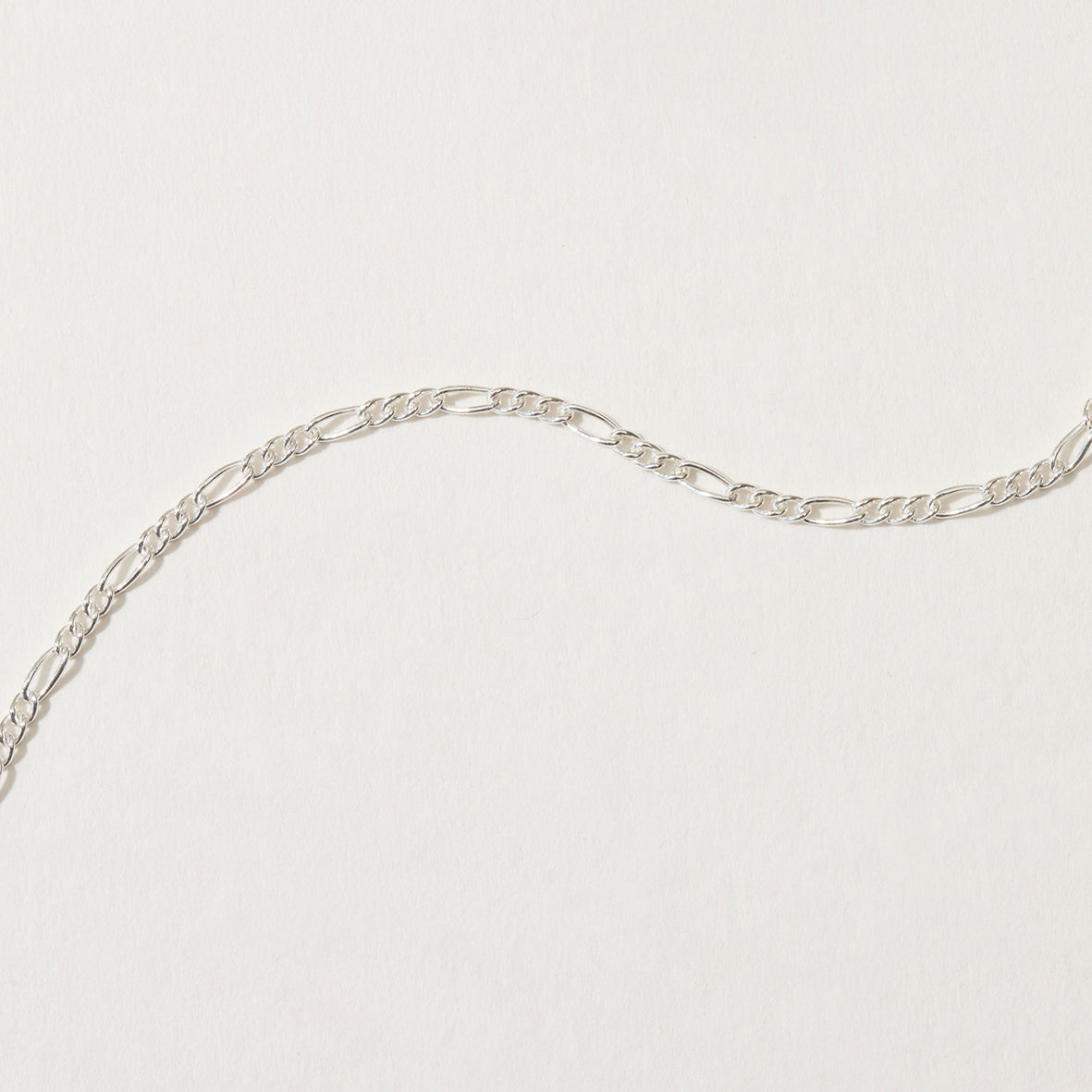 Close-up of sterling silver figaro chain link pattern.
