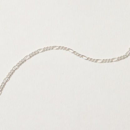 Close-up of sterling silver figaro chain link pattern.
