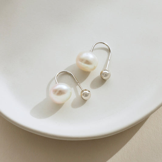 Contemporary freshwater pearl drop earrings with sterling silver ball fastening, white pearl detail.
