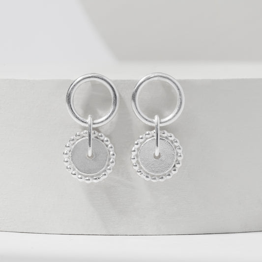 Sterling silver dotted spinner hoop stud earrings displayed on a white background.