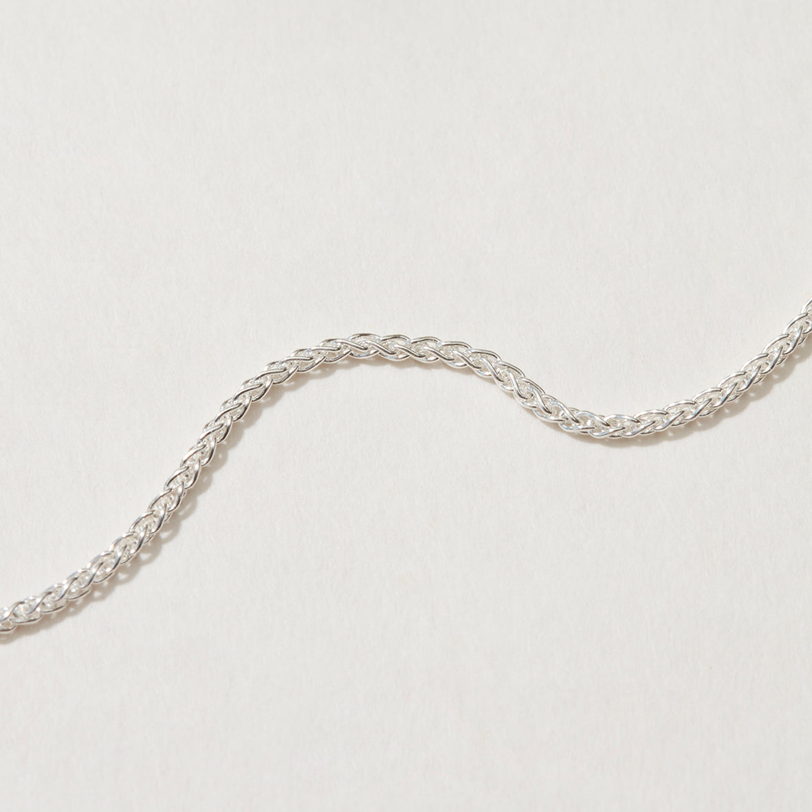 Close-up of Spiga Chain Necklace showcasing intricate silver design.