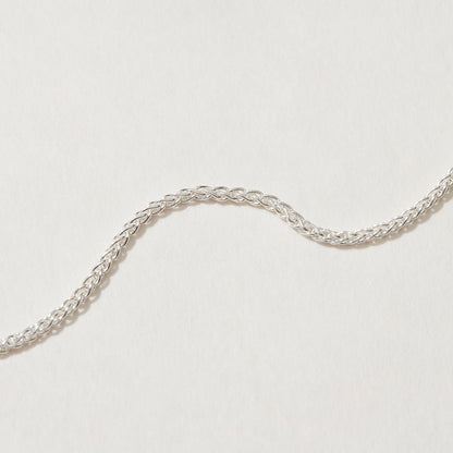 Close-up of Spiga Chain Necklace showcasing intricate silver design.