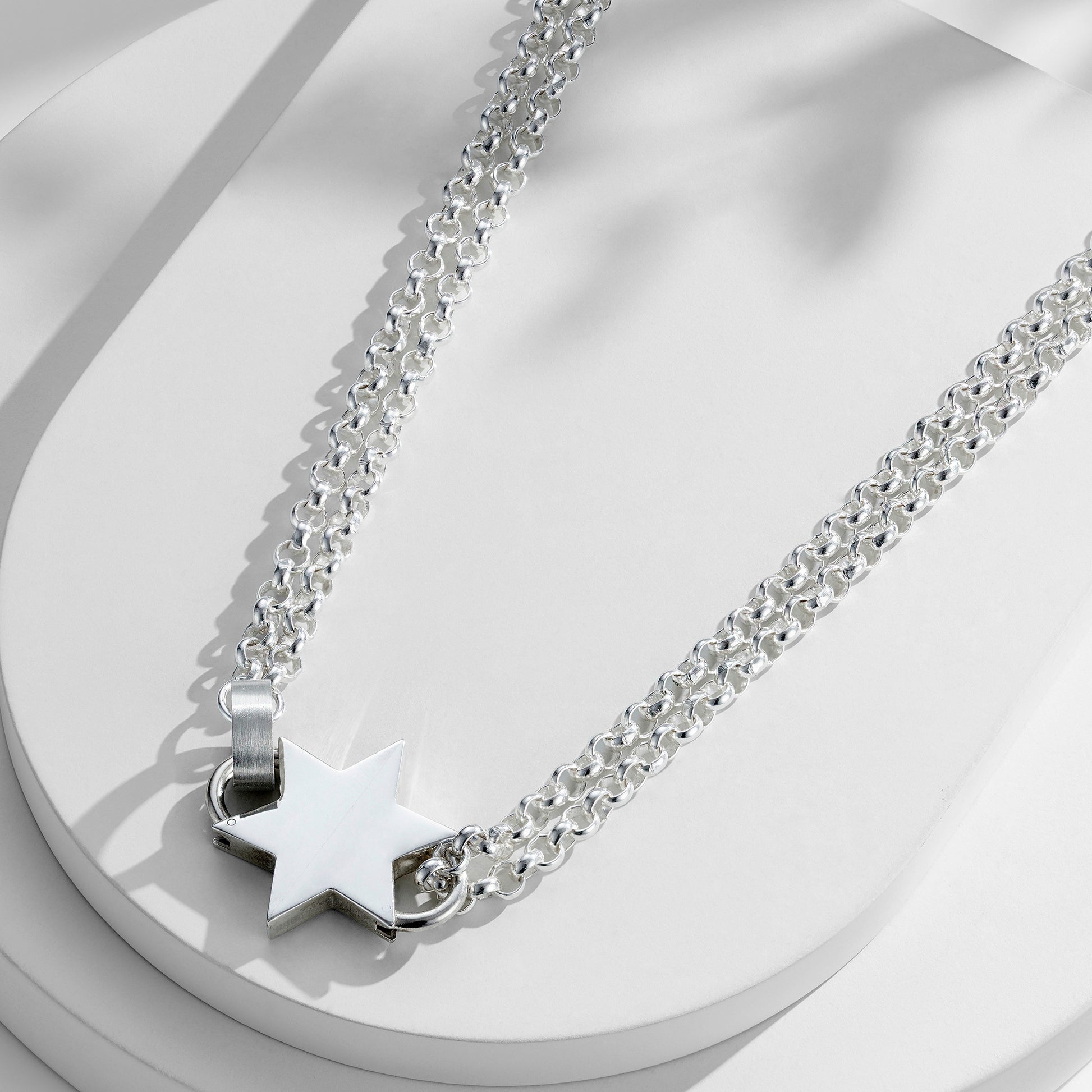 Sterling silver star pendant necklace on a double-layer belcher chain, showcasing a striking silver star as the focal point.