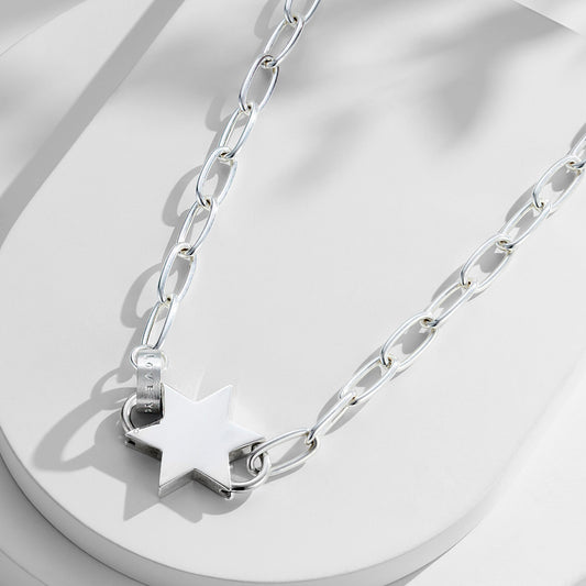 Sterling silver star pendant necklace on a chunky paperclip chain, featuring a bold silver star charm as the centerpiece.